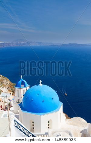traditional blue dome of church with bellfry against blue sea, Oia, Santorini