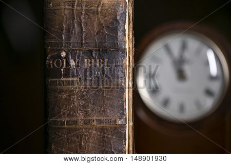 The Holy Bible Next to an Old Clock