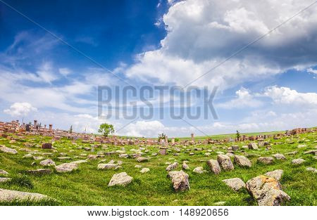 Beautiful view of old stones on lawn against of magnificent blue cloudy sky 