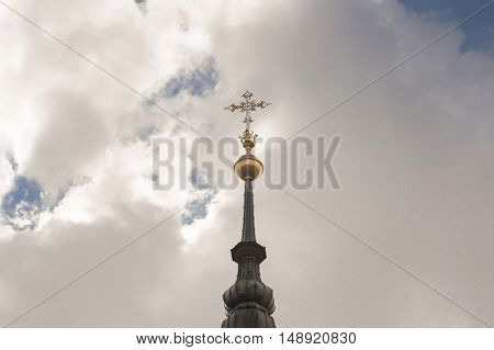 The roofs of the old town a gold cross on a background of blue sky clouds