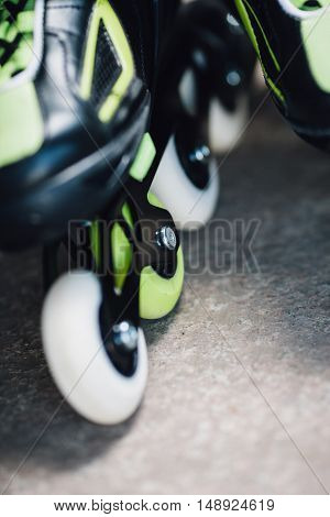 green and white wheels of roller skates closeup