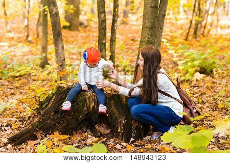 Young mother with her little baby girl in the autumn park.
