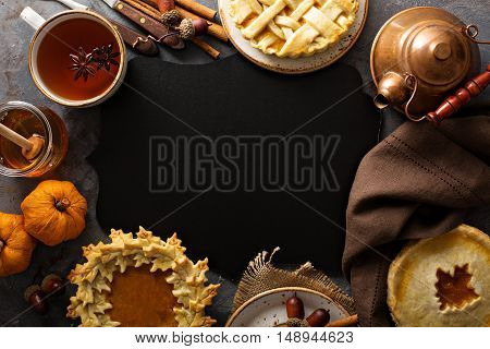 Homemade pumpkin pies decorated with fall leaves copyspace overhead shot