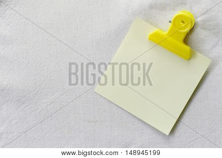 yellow of note paper placed on White fabric backgroundDesign ideas can be Entered your Message into the space as needed.