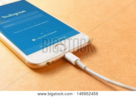 LAMPHUN THAILAND - AUGUST 15 2016: Screen shot Instagram application using Iphone6 charging with power bank on wood board. Instagram is largest and most popular photograph social networking.