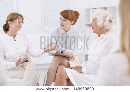 Woman with glasses talking to her friends in bright interior