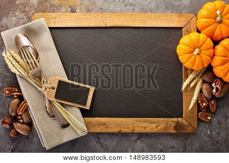 Cooking and eating in fall season, forks and spoon in a rustic autumn table setting with chalkboard copyspace