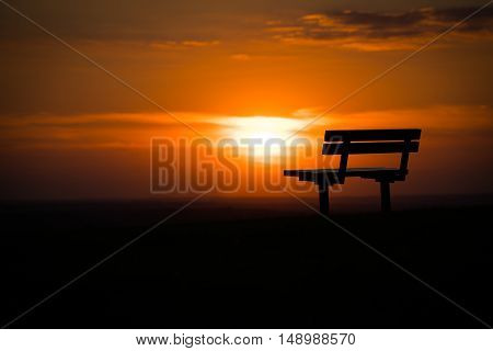 A bench on a hill in Epsom at sunset.