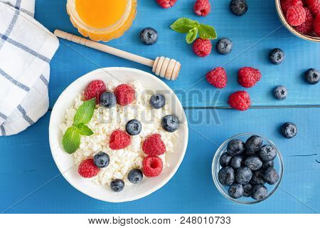 Ricotta With Fresh Berries And Honey On Blue Table. Cottage Cheese, Curd Cheese Or Tvorog With Berri