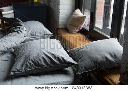 Gray Pillows On The Bed At Window In Bedroom
