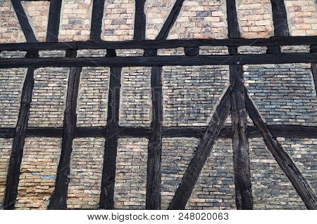 Fragment Of An Ancient Stone Brick Wall With Wooden Beams Close-up. Reconstructed Half-timbered Hous