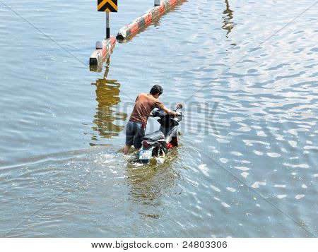 PHATHUMTRANI, THAILAND - 21 oktober: Man duwt Hallo motor door water tijdens de ergste overstromingen 