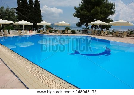 Lefkada, Greece - May 11, 2013: View Of The Blue Pool And White Umbrellas In Modern Hotel On The Coa