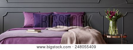 Fresh Purple Tulips In Glass Vase Placed On Metal Bedside Table Standing Next To Bed With Violet She