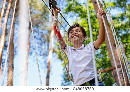 Brave Kid. Happy Preteen Boy Having Fun At Adventure Park And Smiling Happily While Walking Down Tra
