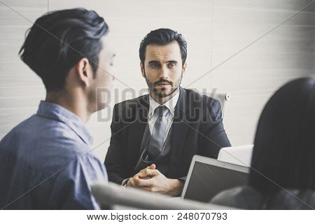 Young Business People Working Together With Serious Emotion. Business People Takling In Modern Offic