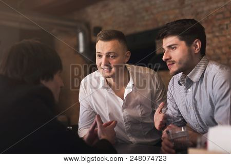 Handsome Smiling Friends Drinking Whiskey And Communicating With Cheerful Bartender In Pub, Copy Spa