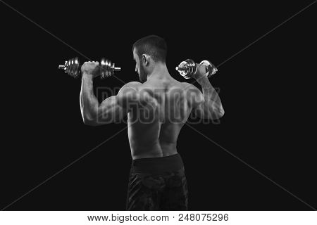 Athletic Young Man With Dumbbell On Black Background, Making Strenth Biceps Exercises, Black And Whi