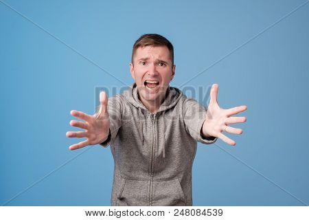 Studio Portrait Of European Man Pulling His Hands Ahead. Do Not Leave Me Alone Concept.