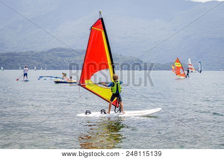Little Boy Is Learning How To Windsurf In Domas At Lake Como, Italy.