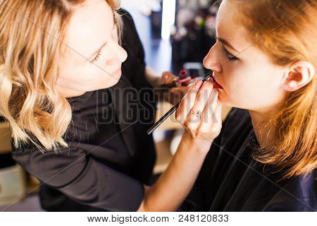 Hand Of Make-up Master, Painting Lips Of Young Beauty Model Girl .