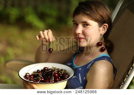 Sweet Cherry Merry In Human Hand With Teenager Girl On Background Close Up Summer Outdoor Photo