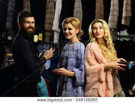 Man And Girls With Happy Faces Hold Wallets On Clothes Background. Friends In Shop: Ladies And Gentl