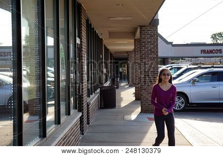 Joliet, Illinois / United States - August 7, 2017: A Girl Walks Past The Front Entrance Of The Abri 