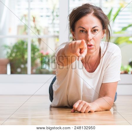 Middle aged woman pointing with finger to the camera and to you, hand sign, positive and confident gesture from the front