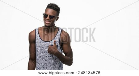 Young african american man happy with big smile doing ok sign, thumb up with fingers, excellent sign