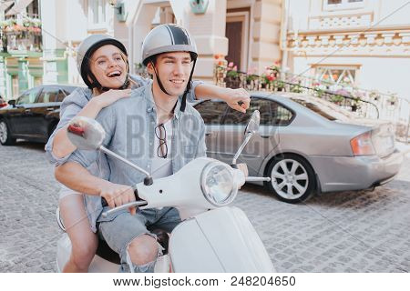 Happy Girl Is Riding On Bike With Her Boyfriend. They Are Looking Straight Forward. Guy Is Smiling. 