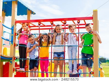 Group Of Children On Playground Climbing The Net