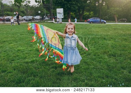Smiling Little Cute Child Baby Girl In Denim Dress Walking, Play With Colorful Kite And Have Fun In 