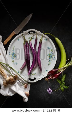Plate With Sicilian Agricultural Products: Eggplant Perlina Variety, Garlic, Spring Red Onions And A