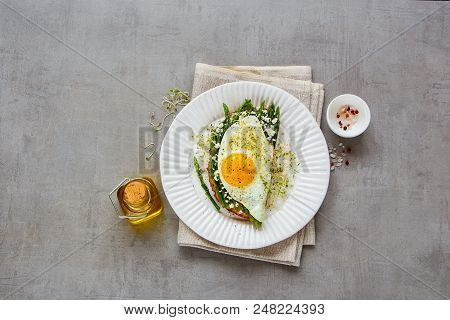 Flat Lay Of Spring Sandwich Plate. Green Aspargus, Fried Egg, Feta Cheese And Micro Greens Over Ligh