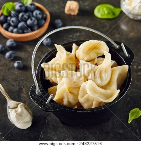 Dumplings with Blueberries. Berriesjiaozi, Dimsum, Momo or Ha Gao on Dark Background. Asian Food of Dough Based on Flour Stuffed with Meat, Fish, Vegetables, or Sweets