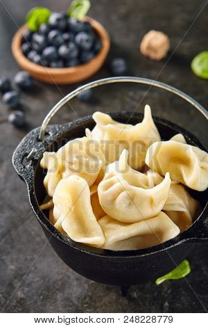 Dumplings with Blueberries. Berriesjiaozi, Dimsum, Momo or Ha Gao on Dark Background. Asian Food of Dough Based on Flour Stuffed with Meat, Fish, Vegetables, or Sweets
