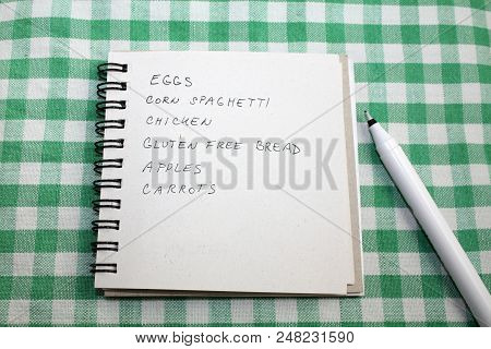 Shopping List On A Tartan Green Tablecloth With A Pen