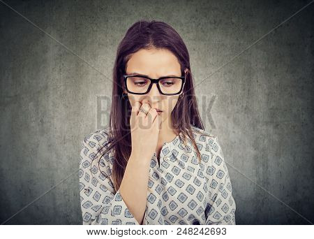 Nervous Woman Biting Nails And Looking Down Feeling Insecure