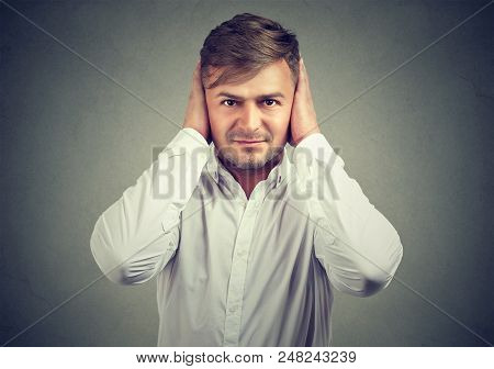 Man In White Shirt Covering Ears With Hands Ignoring Noise And Asking For Quiet.