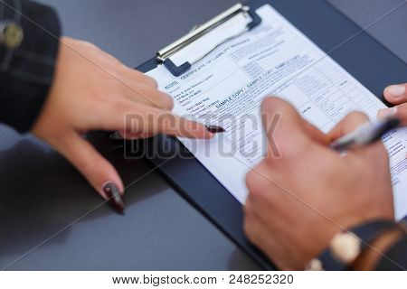 A Speeding Ticket For A Girl Is Written Out By A Man With Clocks On The Hand.