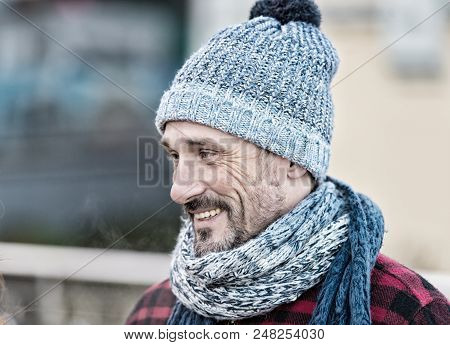 Aged Man In Winter Hat And Scarf. Portrait Of Smiling Guy On Street. Guy In Knitted Scarf And Hat