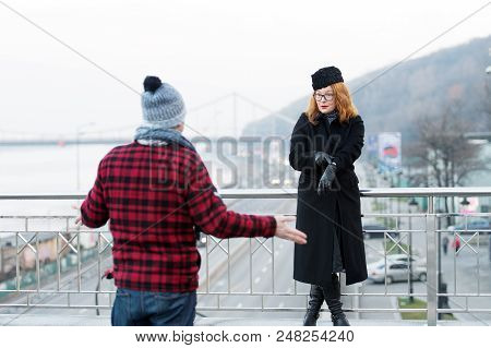 Guy Delayed To Date. Woman Shows To Watches On Arm. Man Spread His Arms From The Strong Woman. Delay