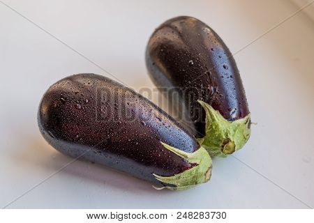 Fresh Juicy Organic Eggplants With Green Leaves. Isolated On White Background