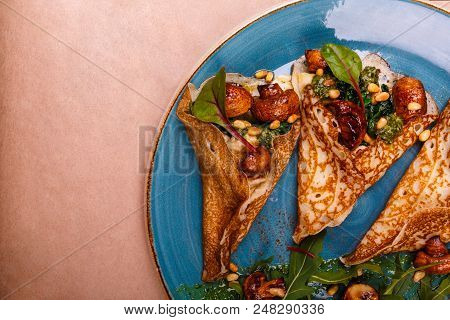 There Is A Blue Plate Full Of Folded Pancakes With Vegetarian Fillings Consisting Of Mushrooms And S