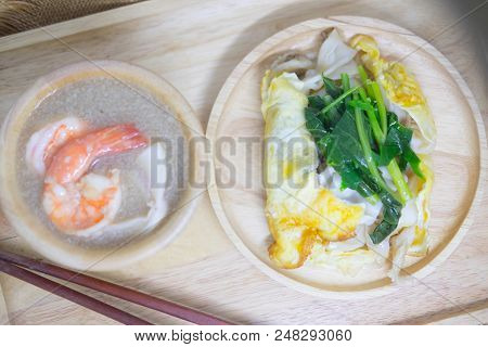 Stir-fried Noodle With Seafood And Kale In Gravy Sauce Served On Wooden Dish
