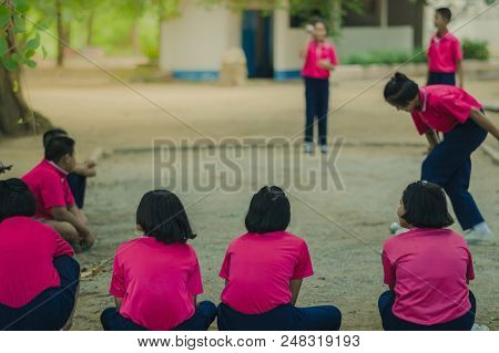 Friendly Students Playing Petanque In The Afternoon At School.