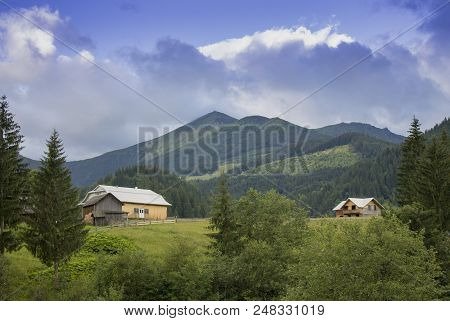 Photo Of Mountain Village In The Summer Under Beautiful Cloudy Sky. Ukraine, Carpathians, Dzembronia
