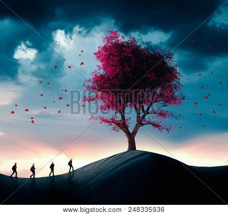 Group Of Travelers Walking In The Desert To A Big Tree.