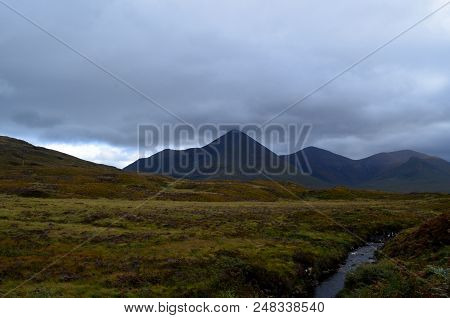 Beautiful Country Side With Mountains, Fields And A Stream
